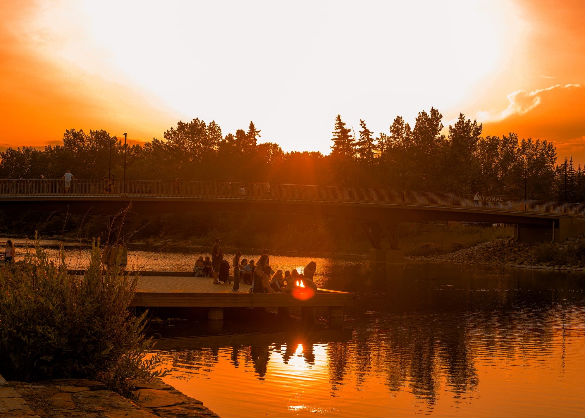 Golden-hour view of a Calgary river pathway and bridge